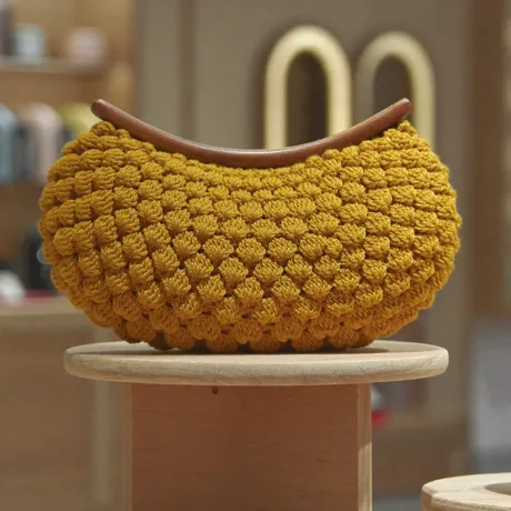 Bolso clutch tejido tipo concha, tono mostaza