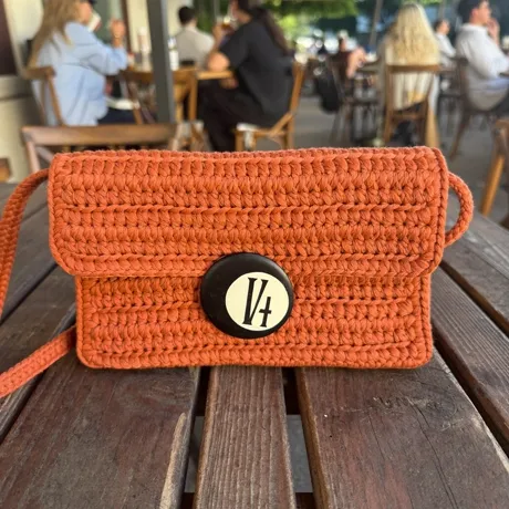 Bolso tejido con hebilla circular, tono terracota