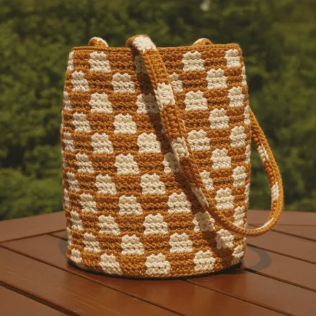 Bolso tejido tipo balde, tono caramelo y crema
